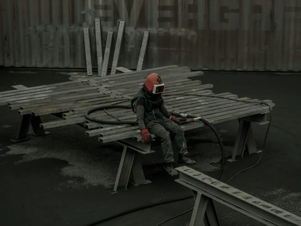 Abrasive blaster at work in full protective gear
