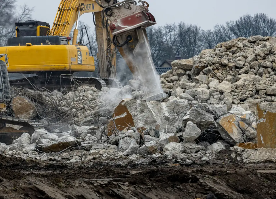 Hydraulic breaker demolishing concrete